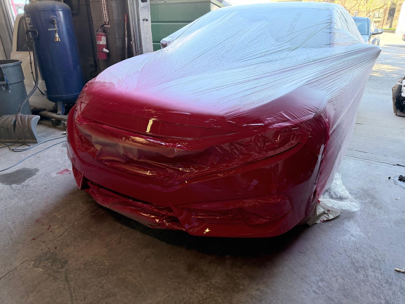 Carro rojo protegido durante el proceso de pintura